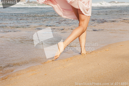 Image of The young woman running on the beach