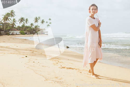 Image of Woman walking on the beach sand