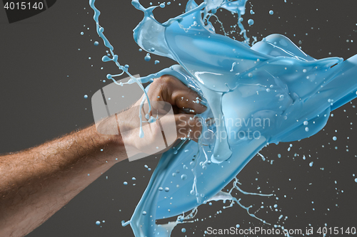 Image of Close-up of a man\'s fist punching through liquid