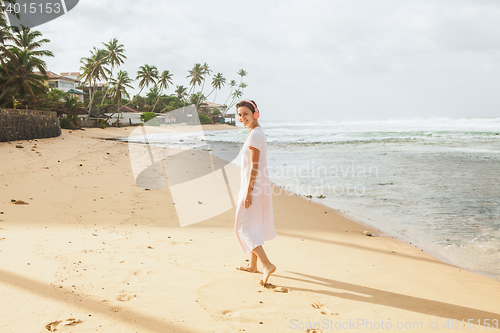 Image of Woman walking on the beach sand