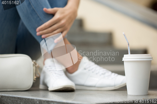 Image of stylish woman drinking coffee to go in a city street