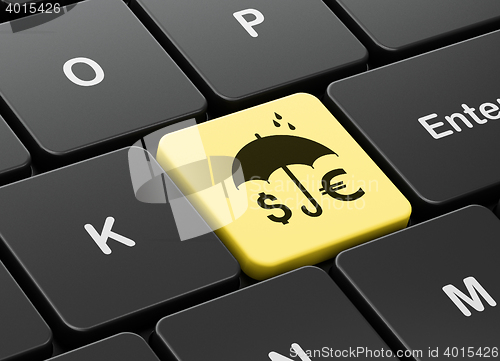 Image of Protection concept: Money And Umbrella on computer keyboard background