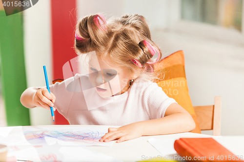 Image of The young mother and her little daughter drawing with pencils at home