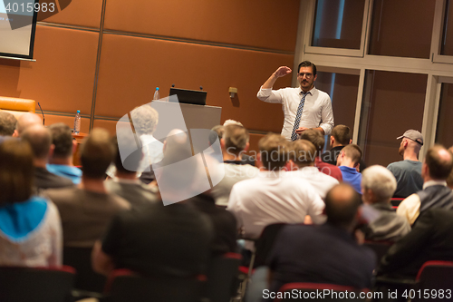 Image of Business speaker giving a talk in conference hall.