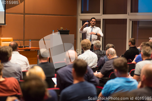 Image of Business speaker giving a talk in conference hall.