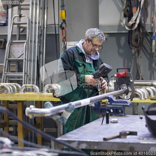 Image of Industrial worker setting orbital welding machine.