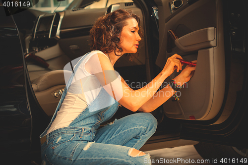 Image of mechanic with a screwdriver preparing the car for the journey