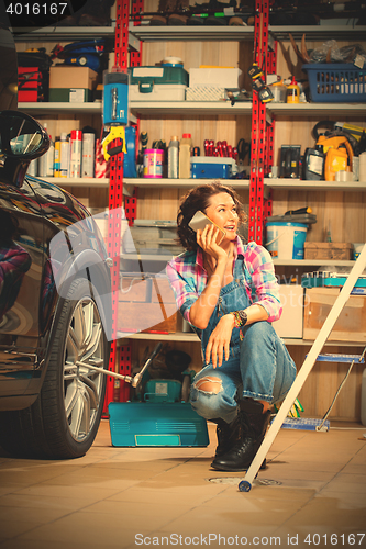 Image of mechanic in an auto repair shop talking on mobile