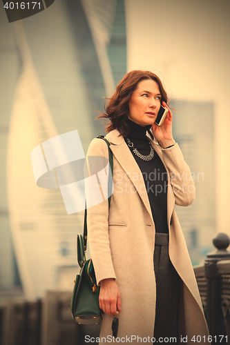 Image of woman in a bright coat talking on the phone