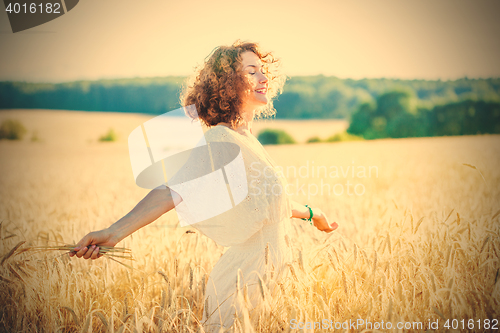 Image of smiling happy woman in wheat field