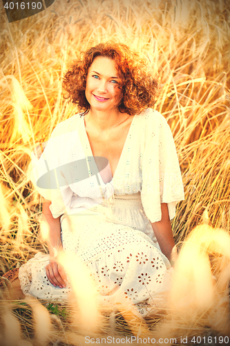 Image of middle aged pretty smiling woman outdoors