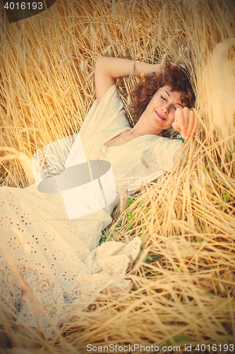 Image of happy sleeping woman in wheat field