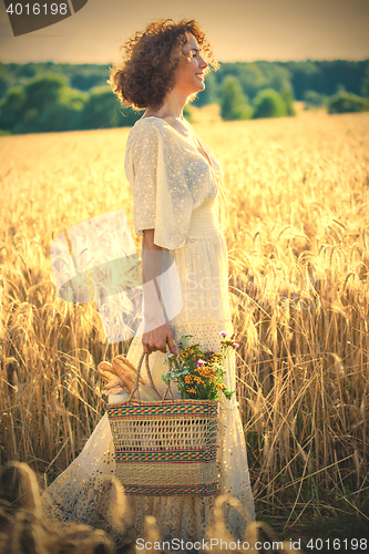Image of Woman Outdoors with wicker bag with natural meal 