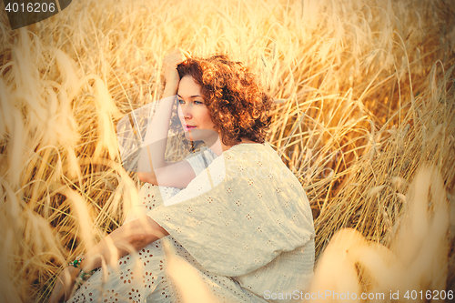 Image of middle aged beautiful smiling woman in wheat field