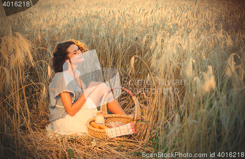 Image of middle aged beautiful smiling woman with basket outdoors