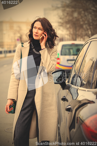 Image of fashion. beautiful woman in a bright coat talking on the mobile