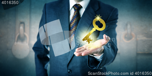 Image of Business Man Offering A Golden Key In Open Palm