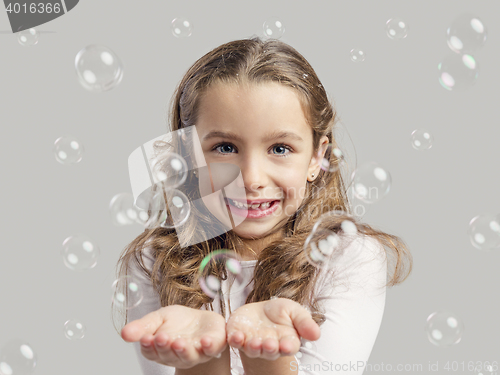 Image of Girl playing with soap bubbles