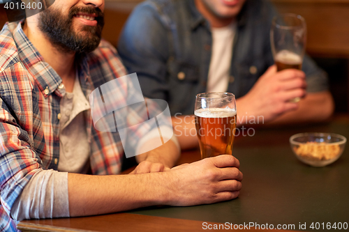 Image of happy male friends drinking beer at bar or pub