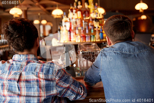 Image of close up of male friends at bar counter in pub