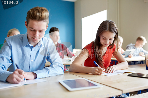 Image of group of students with books writing school test