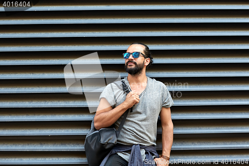 Image of man with backpack standing at city street wall