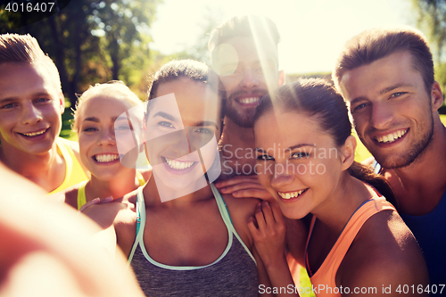 Image of happy friends taking selfie with smartphone