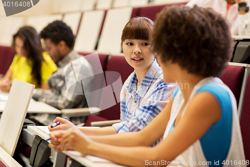 Image of group of students talking in lecture hall