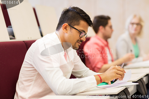 Image of group of students with notebooks in lecture hall