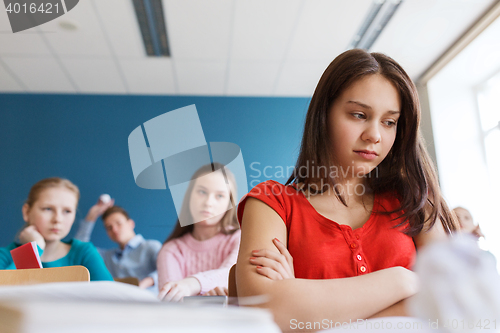 Image of students gossiping behind classmate back at school