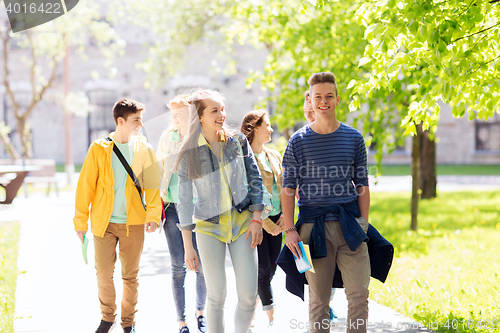 Image of group of happy teenage students walking outdoors