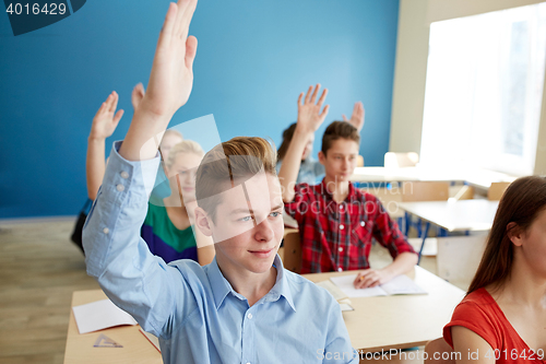 Image of group of students raising hands at school lesson