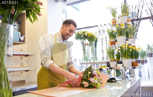 Image of florist wrapping flowers in paper at flower shop