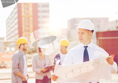 Image of group of builders with tablet pc and blueprint