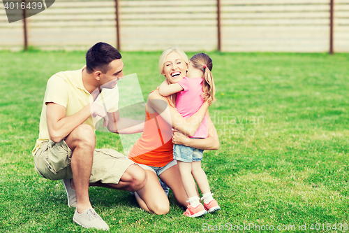 Image of happy family hugging outdoors