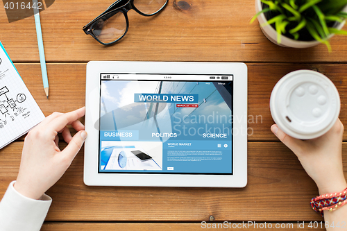 Image of close up of woman with tablet pc on wooden table