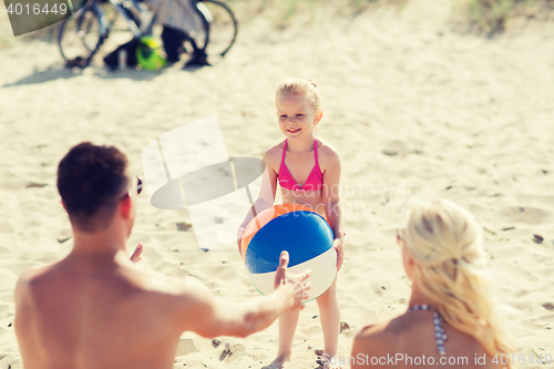 Image of happy family playing with inflatable ball on beach