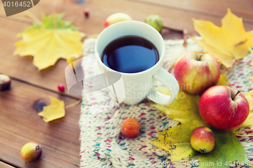 Image of close up of tea cup on table with autumn leaves