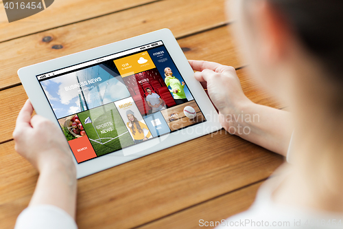 Image of close up of woman with tablet pc on wooden table