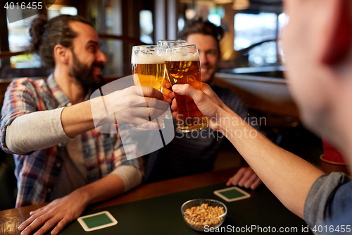 Image of happy male friends drinking beer at bar or pub