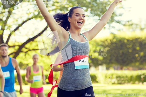 Image of happy young female runner winning on race finish