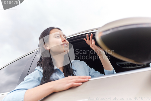 Image of happy young woman driving in car