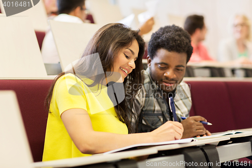 Image of group of students with notebooks in lecture hall