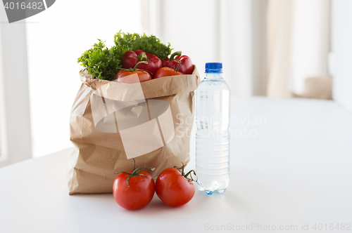 Image of basket of fresh vegetables and water at kitchen