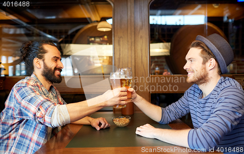 Image of happy male friends drinking beer at bar or pub