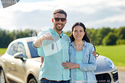 Image of happy man and woman with car key hugging 