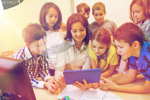 Image of group of kids with teacher and tablet pc at school