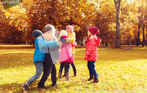Image of group of happy children hugging in autumn park