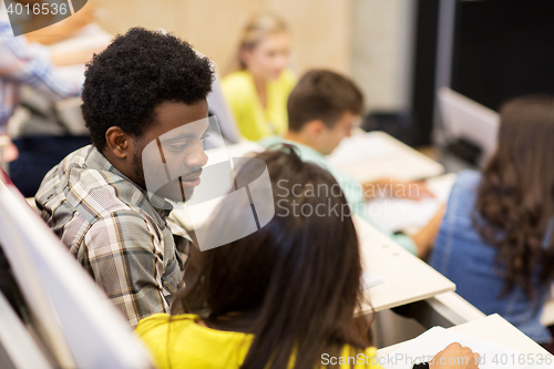 Image of group of students talking in lecture hall