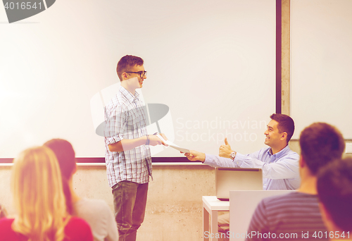 Image of group of students and smiling teacher with notepad